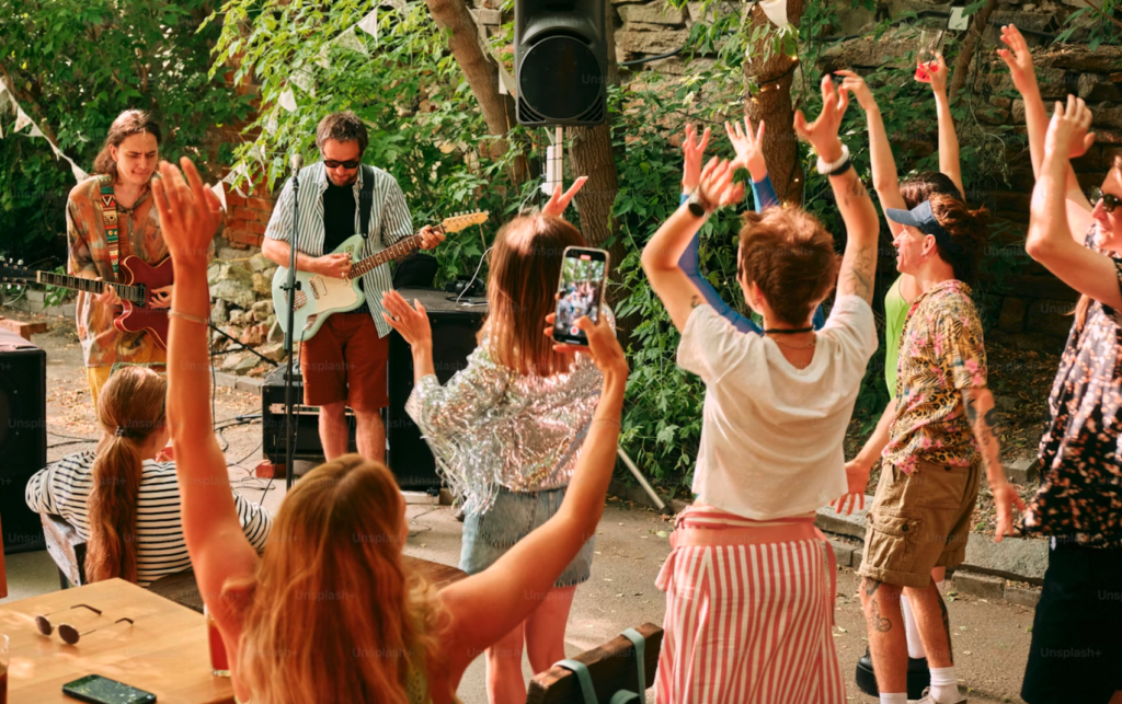 fête de la musique : des jeunes en train de danser et écouter un musicien avec sa guitare